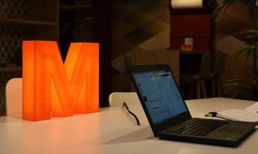 MITS Laptop vor leuchtendem M Notebook MITS davanti a M luminosa
